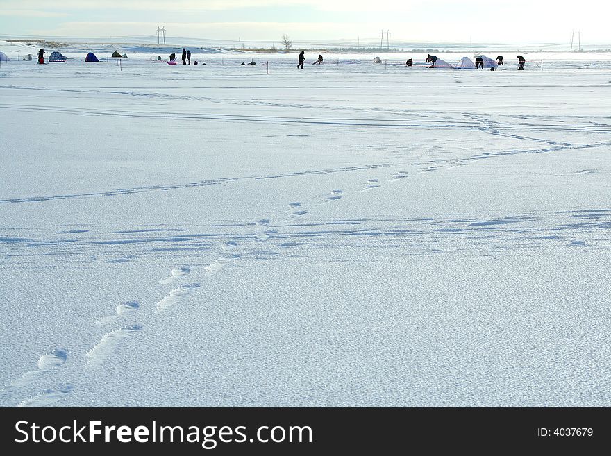 Winter landscape with fishermen