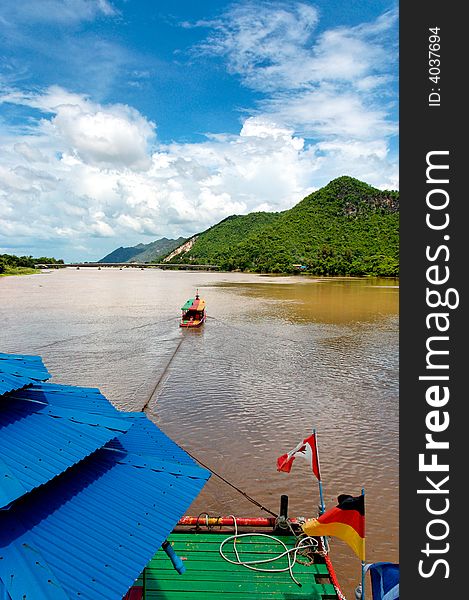 River boat towing raft down river in asia