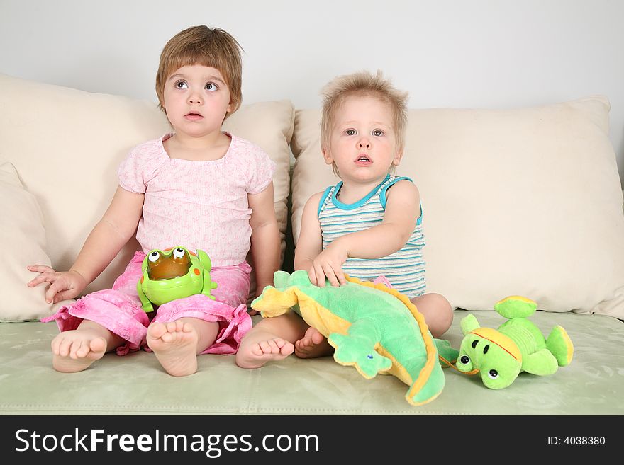 Two children on sofa with toys. Two children on sofa with toys