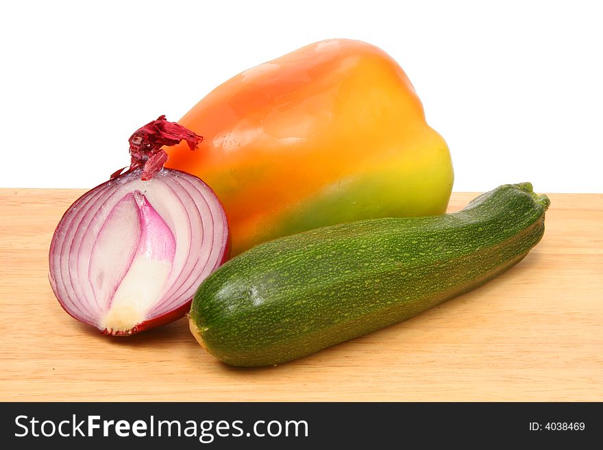 Onion,courgette and pepper on wooden board. Onion,courgette and pepper on wooden board