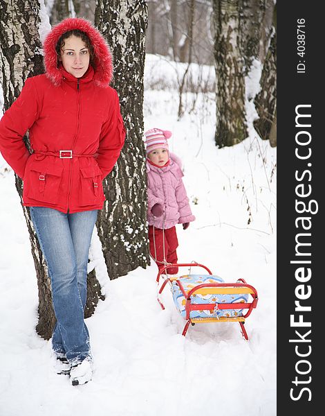 Mother and child stand in park at winter