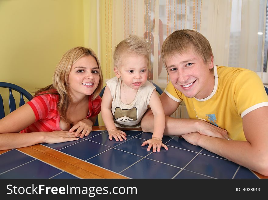 Parents With Child Sit At Table