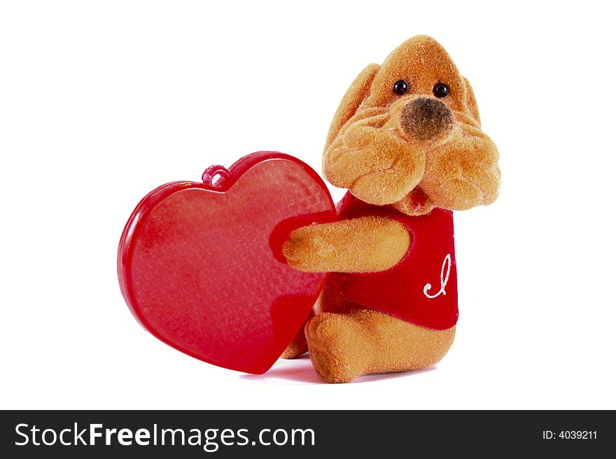 Toy dog with a plastic red heart. Isolated object on white background. Toy dog with a plastic red heart. Isolated object on white background