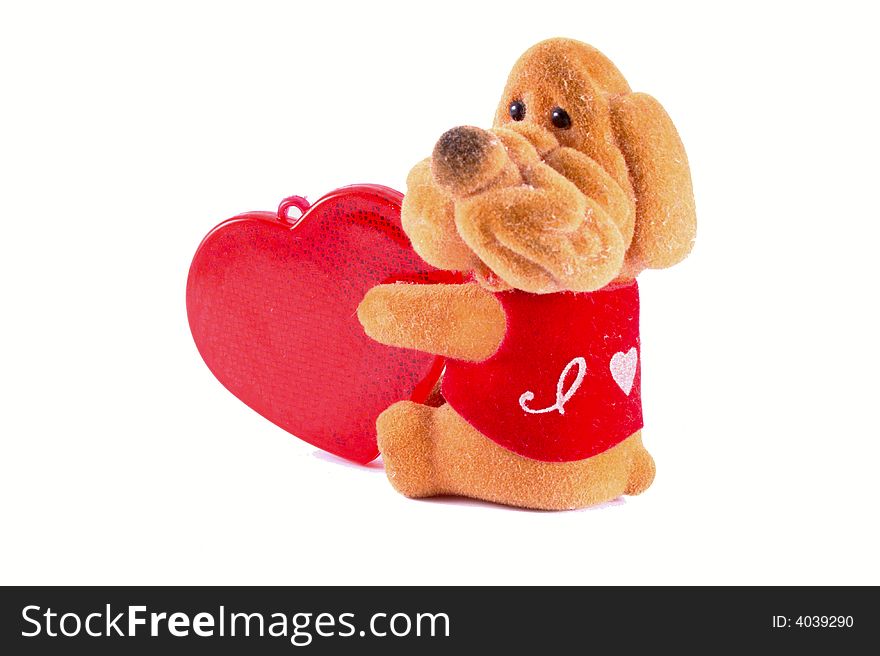 Toy dog with a plastic red heart. Isolated object on white background. Toy dog with a plastic red heart. Isolated object on white background