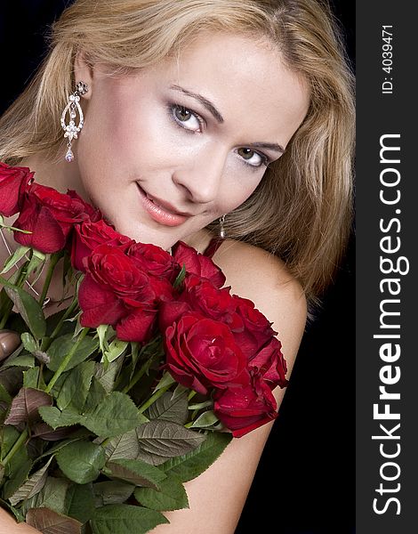Beautiful blond woman hugging red roses and smelling them. Beautiful blond woman hugging red roses and smelling them