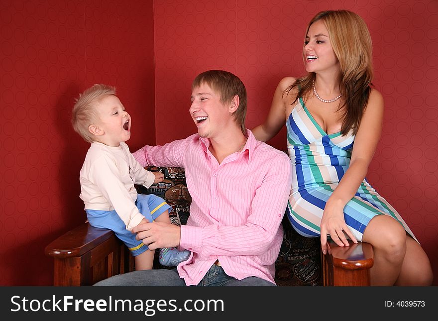 Young family laughing in red room