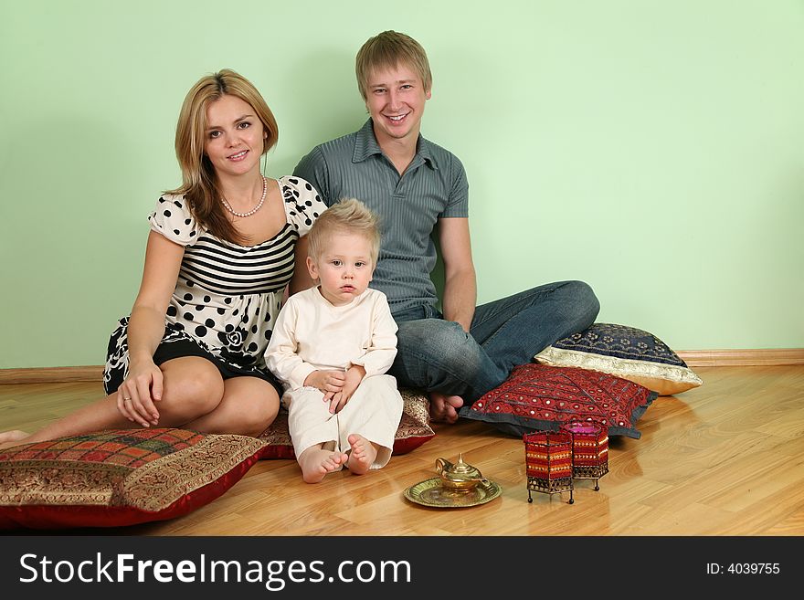 The family sit on floor on pillow