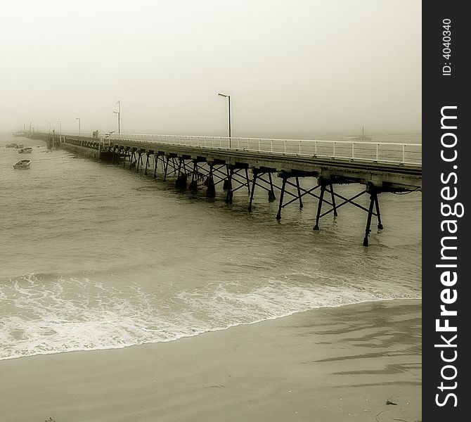 A pier disappearing into the fog in black and white. A pier disappearing into the fog in black and white