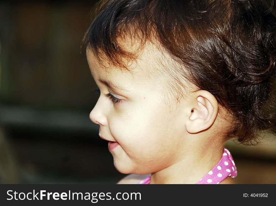 Beautiful baby girl looking to the side.  She has reddish brown hair. Beautiful baby girl looking to the side.  She has reddish brown hair.