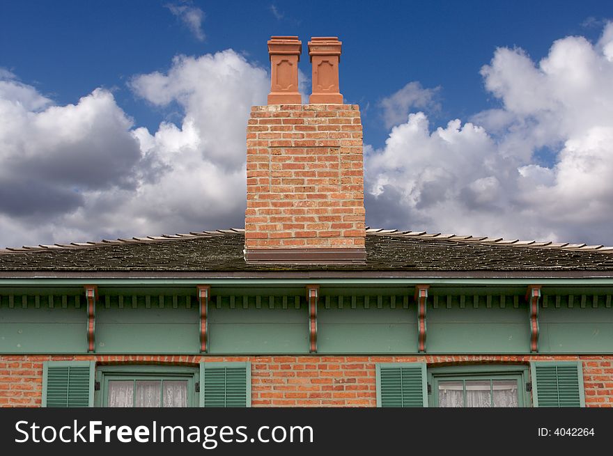 Classic Home Facade with a Dual Chimney dramatic clouds and blue skies