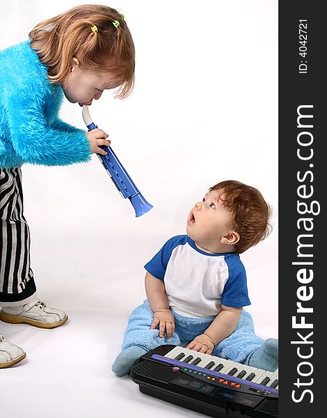 Small boy plays with the electronic piano. Girl plays on the pipe. Small boy plays with the electronic piano. Girl plays on the pipe