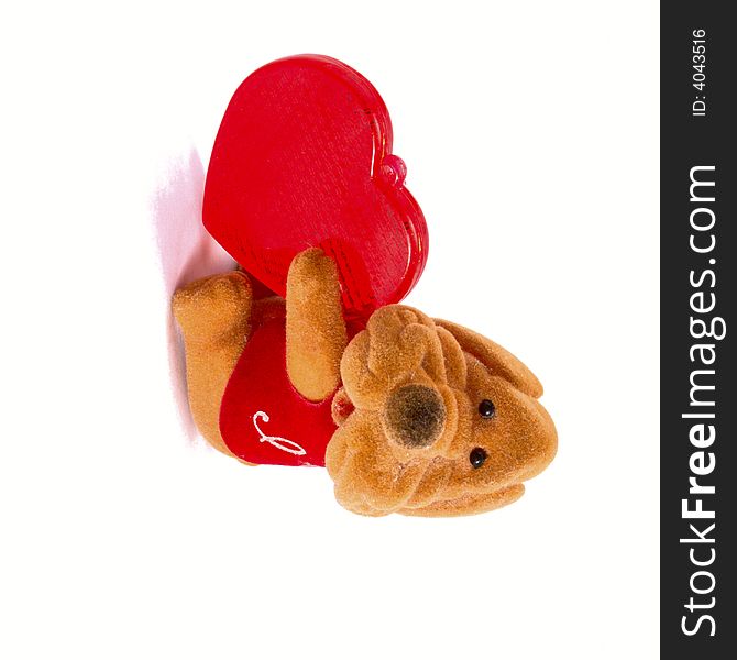 Toy dog with a plastic red heart. Isolated object on white background. Toy dog with a plastic red heart. Isolated object on white background