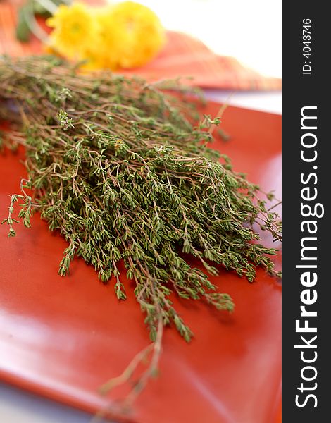 Freshly picked thyme sprigs on an orange plate. Freshly picked thyme sprigs on an orange plate