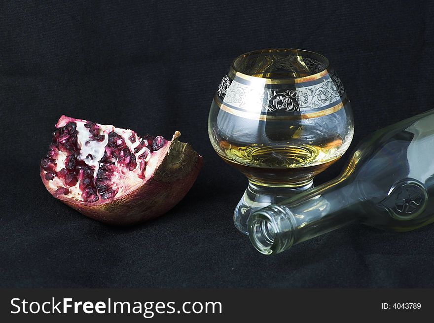 Pomegranate and cognac glass on a black background - food joy