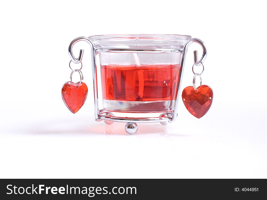 A bright red candle in glass with hearts. A bright red candle in glass with hearts