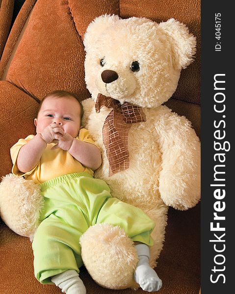 Relaxing small baby with a toy bear