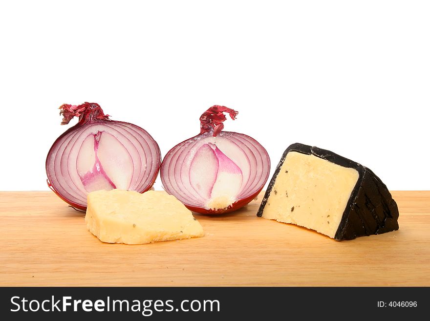 Red onions and Cheddar cheese on a wooden chopping board. Red onions and Cheddar cheese on a wooden chopping board