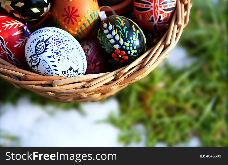 Painted eggs, basket, grass and snow. Painted eggs, basket, grass and snow