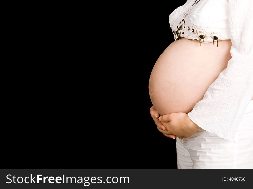 A pregnant lady holding her stomach on a black background