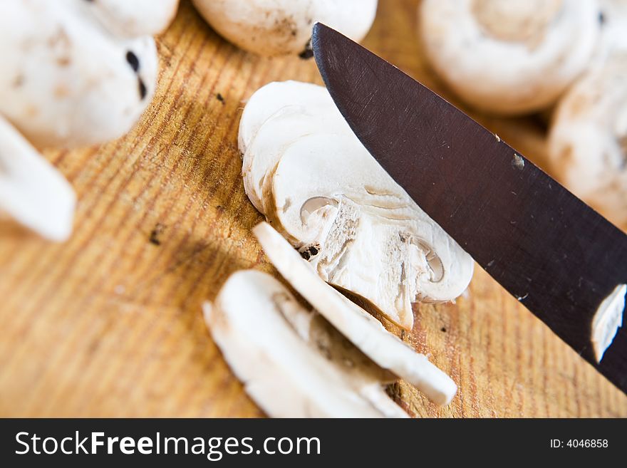 Sliced mushrooms with a knife on a wooden background