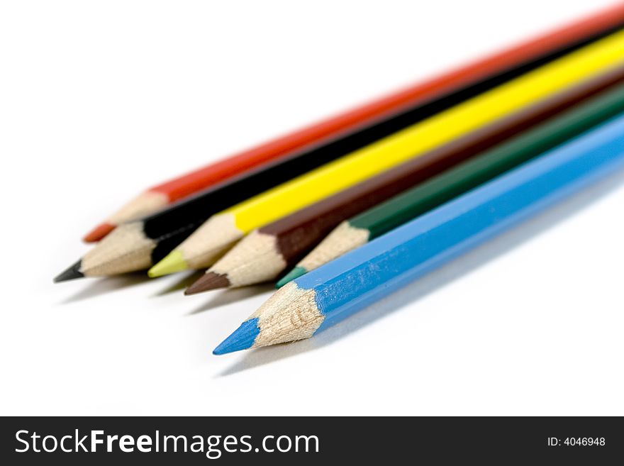 Six coloured pencils over white background