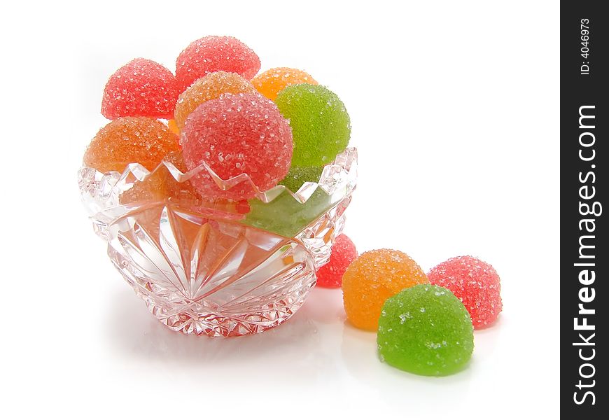 Colour fruit candy in a crystal vase on a white background
