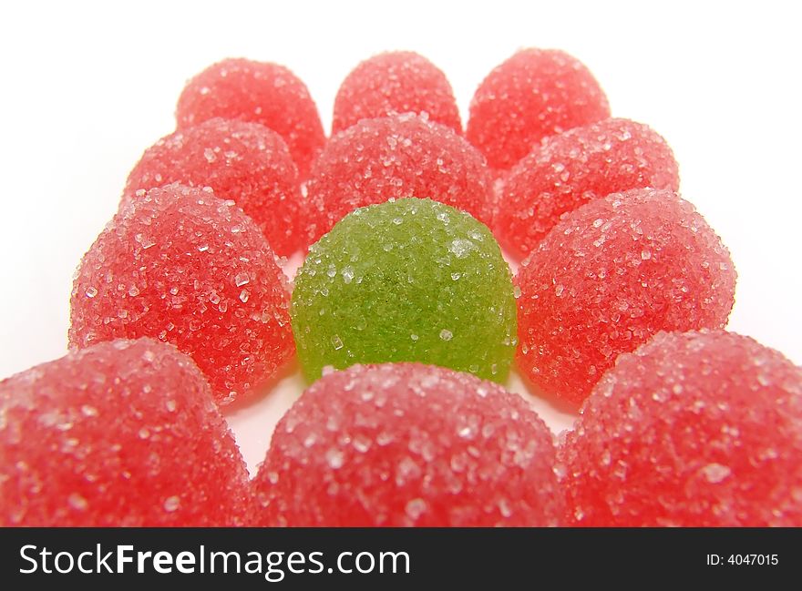 Colour fruit candy on a white background. Green fruit candy in a surrounding of the red.