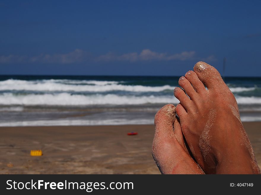 Female feet on back-ground sea in sand