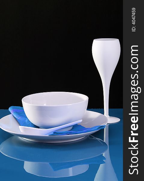 A contemporary dinning table set with plate, bowl and wine glass. A contemporary dinning table set with plate, bowl and wine glass