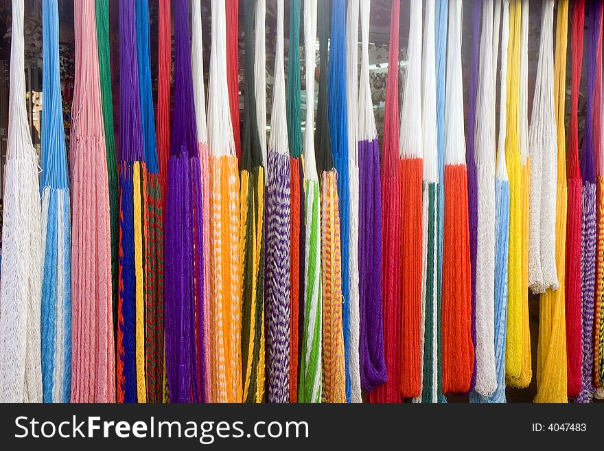 A rack of colorful rope hammocks at a flea market. A rack of colorful rope hammocks at a flea market