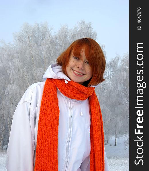 Red-haired girl with orange scarf at winter day