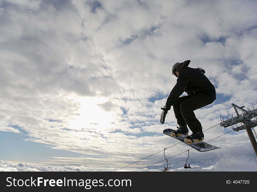 Snowboarder launching off a jump; horizontal orientation, afternoon light.