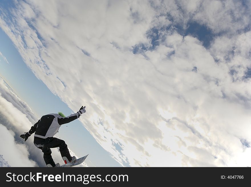 Snowboarder launching off a jump; horizontal orientation, afternoon light.