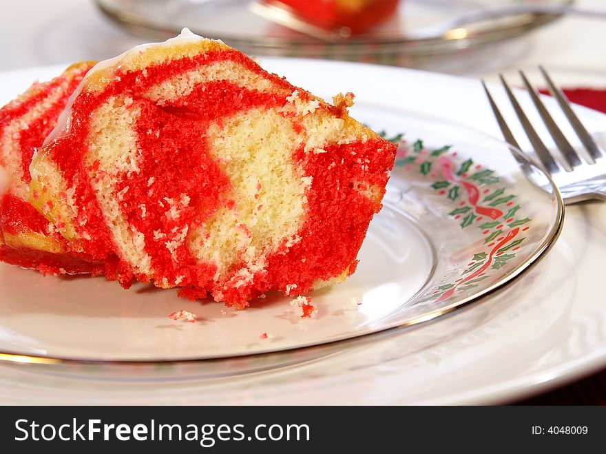 Festive red and yellow swirled Christmas cake on holiday dinnerware.