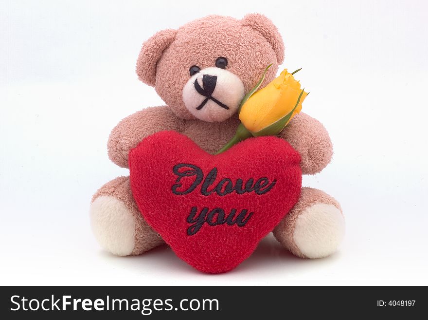 Stuffed bear holding a yellow rose and a heart, with text I love you, on white. Stuffed bear holding a yellow rose and a heart, with text I love you, on white