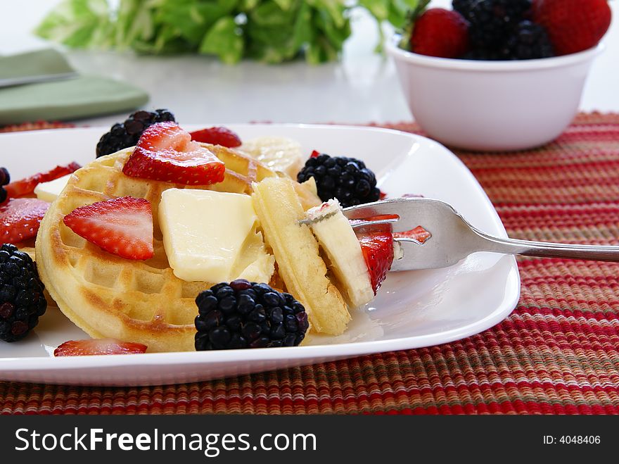 Waffles with strawberries, blackberries, bananas, butter, and light vanilla syrup. Waffles with strawberries, blackberries, bananas, butter, and light vanilla syrup.