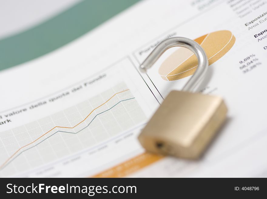 Stock market graph, portfolio and open padlock on top. Shallow depth of field, focus on graph line and pie-chart