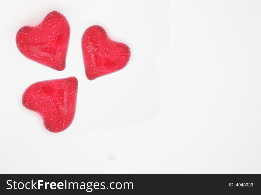 Three little red glitter hearts isolated on white. Three little red glitter hearts isolated on white