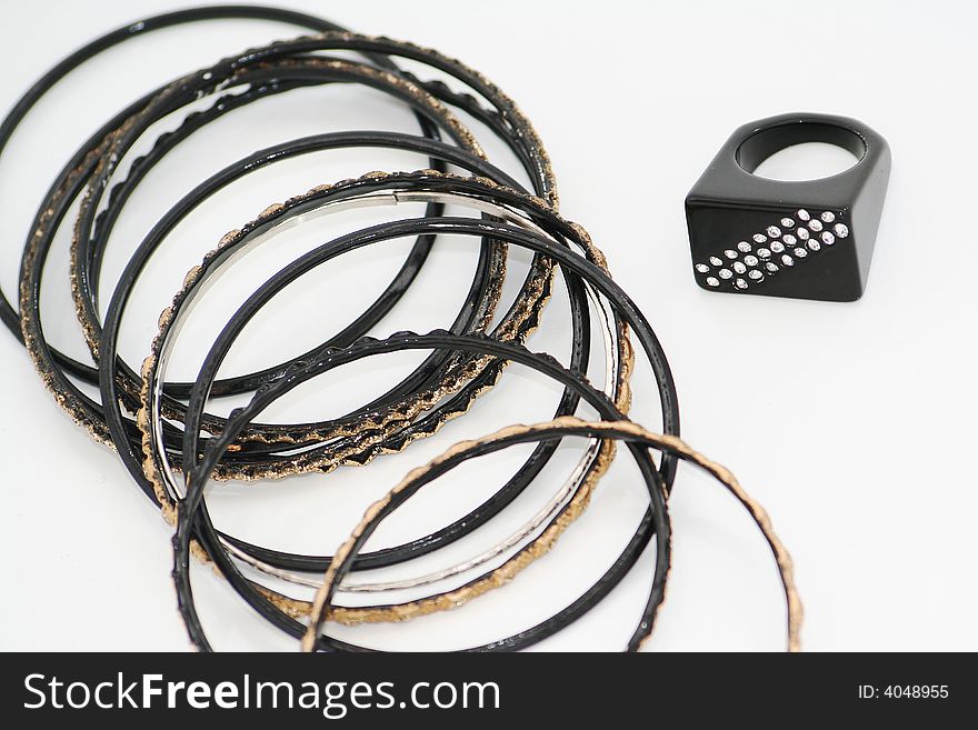 Black and gold bracelets and black ring with diamonds isolated on white. Black and gold bracelets and black ring with diamonds isolated on white