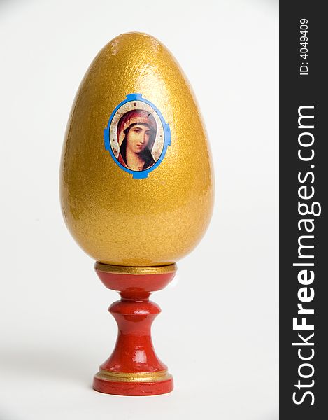 Gold easter egg on a red support with figure. Gold easter egg on a red support with figure.