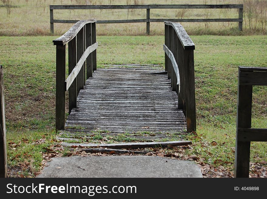 Old wooden bridge, across a small ditch. Looks like a postcard. Old wooden bridge, across a small ditch. Looks like a postcard.