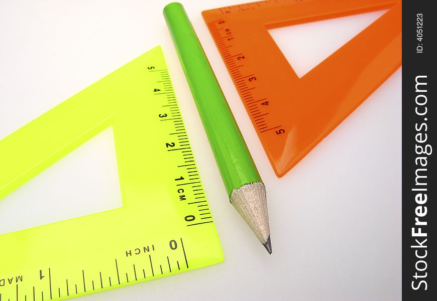 Two triangle ruler and pencil on light background
