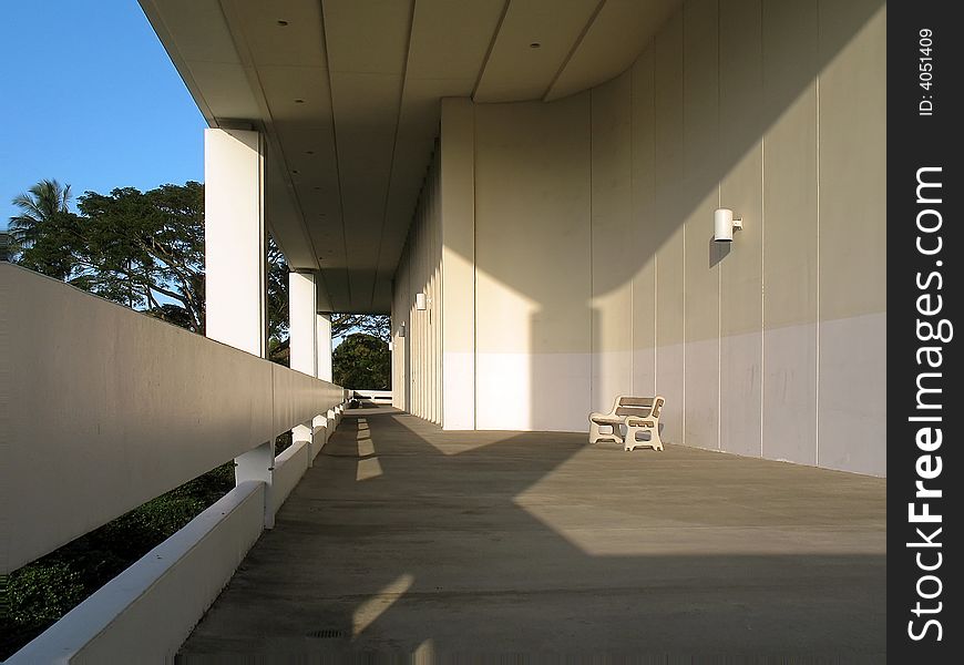 Public space bench in sunlight with dramatic shadows. Public space bench in sunlight with dramatic shadows