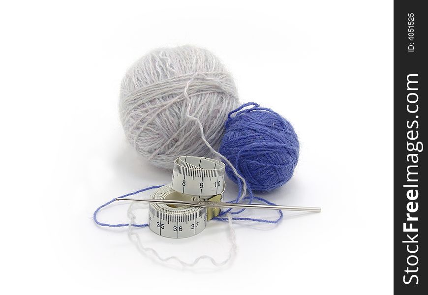 Balls of wool, tape measure and hook on a white background. Balls of wool, tape measure and hook on a white background