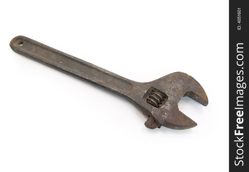 Old rusty adjustable spanner on a white background