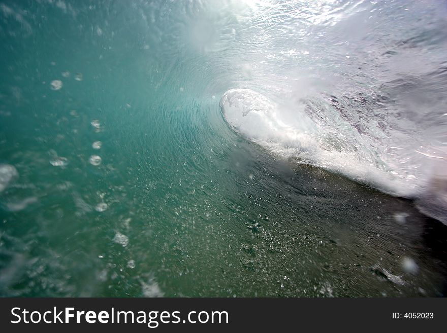 An ocean wave breaks along the shore of Hawaii. An ocean wave breaks along the shore of Hawaii.