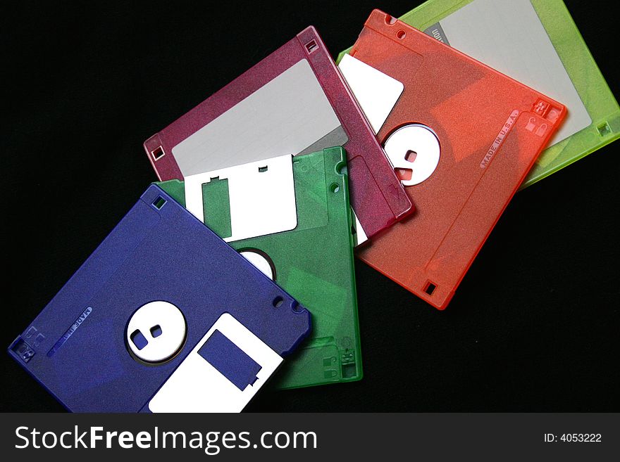 Colourful computer disks on a black background. Colourful computer disks on a black background