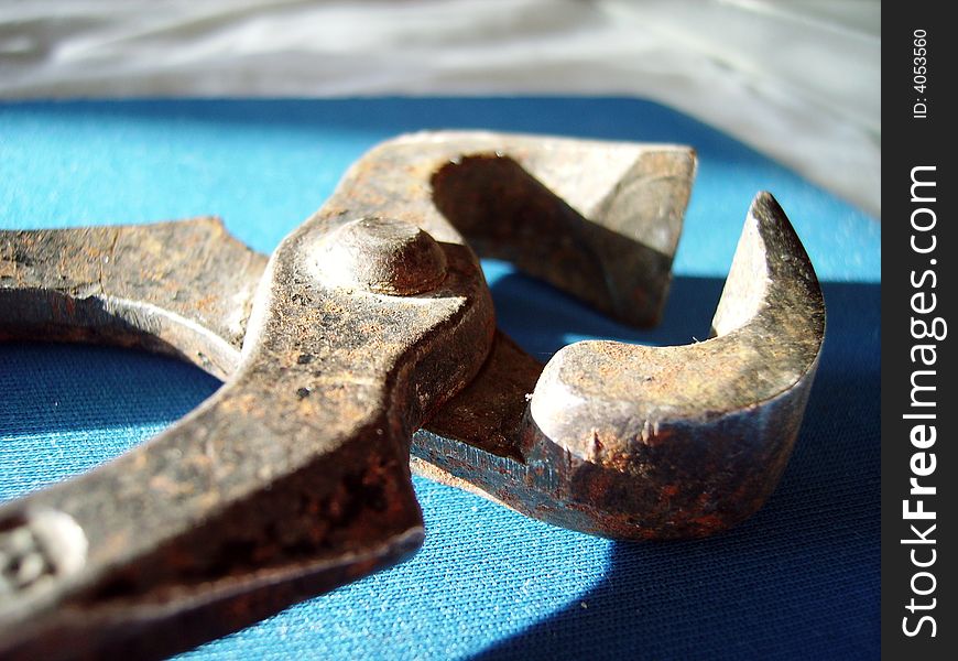 A close detail of an old rusty clamp on blue
