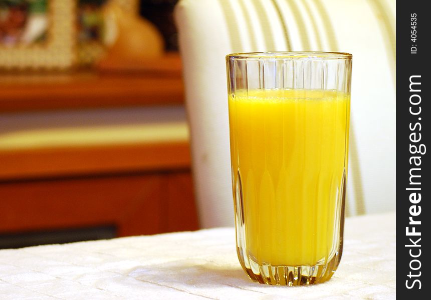 Tall glass of orange juice on table