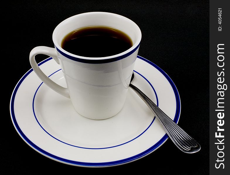 Coffee cup, saucer and spool isolated on black background.